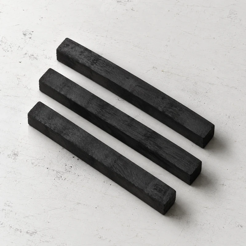 Charcoal sticks on a lightly marked white studio table
